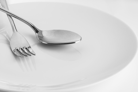 Fork and Spoon in plate on  white tableの写真素材