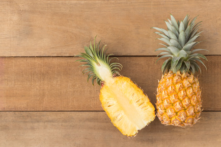 half pineapple on wood table, top view