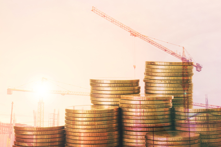 Mortgage concept,mockup house from coin with crane in Construction site background, Double exposure effect styleの写真素材