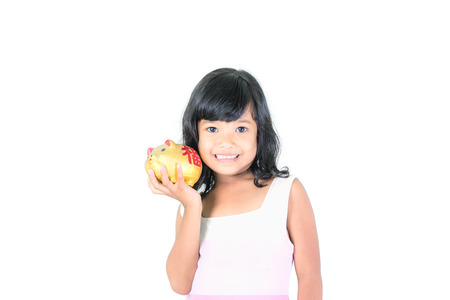Young girl holding piggy bank on white background.saving money concept.の写真素材