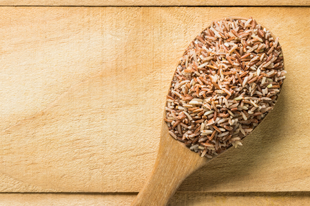 Close up brown rice in  wooden spoon. top viewの写真素材