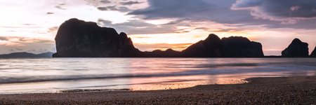 sunset at the sea beach with silhouette mountain, panorama nature background.の写真素材