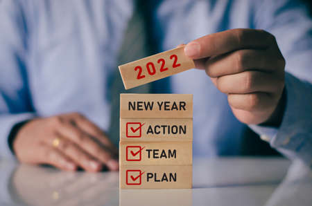 Businessman laying wooden blocks lined up. New year 2022 business planning idea. along with the...