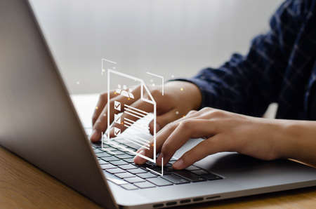 Man's hand collects online document database. Document management concept (DMS) ERP online document database. Businessman working on laptop computer with icons on virtual screen.の写真素材