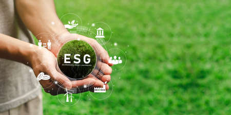 The hand that holds the world ready to use the technology of renewable resources to reduce pollution. In concept icon ESG in hand for the environment, society and sustainable business governance.の写真素材