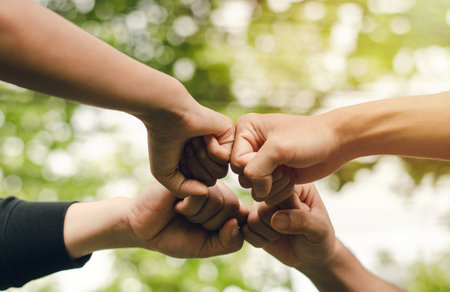4 people join forces, the concept of hand-to-hand to create unity, group of people, hands, teamwork business group by reaching out in a circle The power of work is friendship with business colleagues.の写真素材