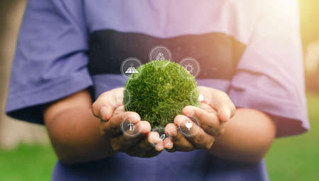 Earth in nature's time in human hands with energy resource icon. Earth day. Energy saving concept.の写真素材