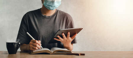 Asian women use phone to worship online. to maintain distance for online church ideasの写真素材