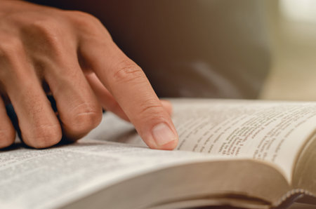 young man pointing to a bible topic and read the Bible on Sundays to receive the blessings of God.の写真素材