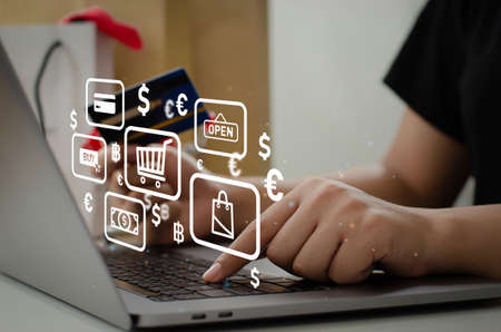 woman holding credit card using computer to shop online at homeの写真素材