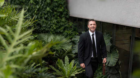 Businessman ceo manager walking up stairs amidst green buildings ESG concept of green business in sustainable development goals Green building Modern building in green city environmental friendlyの写真素材