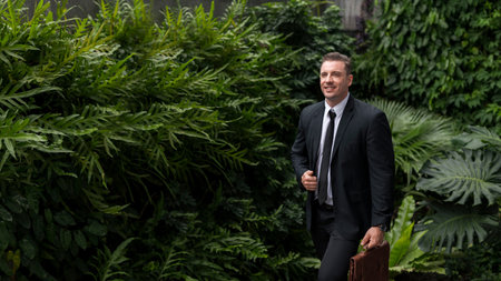 Green business concept, saving the world, protecting the environment, environmentally friendly business, sustainable development. Businessman in the middle of nature, green building.の写真素材