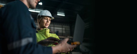 Female engineer who is the chief architect is talking in the machinery factory to solve the problem of the robot's malfunction system. Robot inspection in the assembly plant. Engineering concept.の写真素材