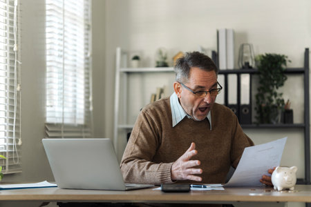 An elderly man celebrates while reviewing retirement savings documents and annual tax audit.
