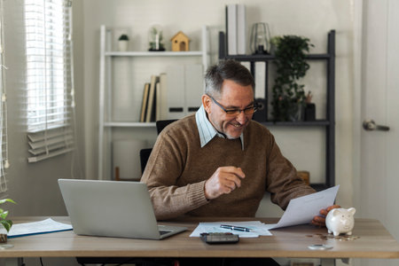 An elderly man celebrates while reviewing retirement savings documents and annual tax audit.