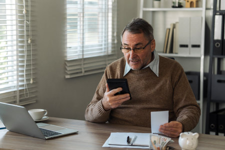Retired old man is shocked by annual tax, debt, arrears on house, tax conceptの写真素材