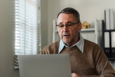 Retired senior man talking to taxman online about annual tax. Tax concept.の写真素材