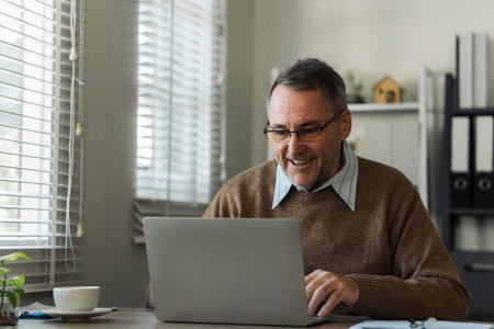 Retired senior man talking to taxman online about annual tax. Tax concept.の写真素材