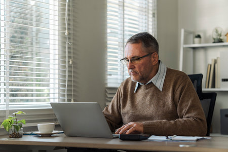Retired senior man talking to taxman online about annual tax. Tax concept.の写真素材