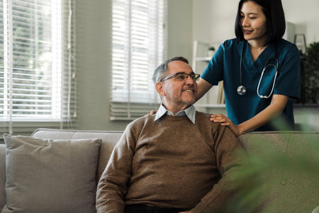 Caregiver encourages and comforts elderly man in nursing home care and confide in caregiverの写真素材