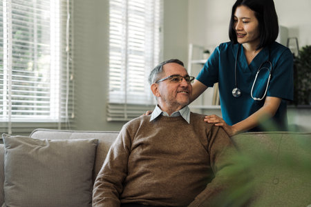 Caregiver encourages and comforts elderly man in nursing home care and confide in caregiverの写真素材