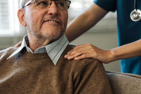 Caregiver encourages and comforts elderly man in nursing home care and confide in caregiverの写真素材