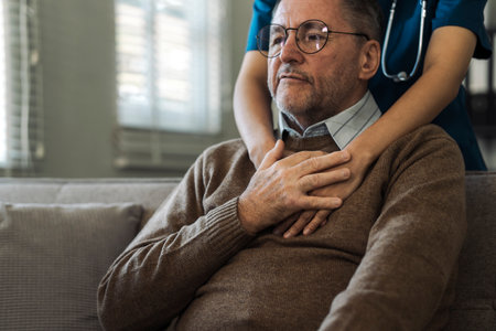 Caregiver encourages and hugs elderly man in nursing home care and confide in caregiverの写真素材