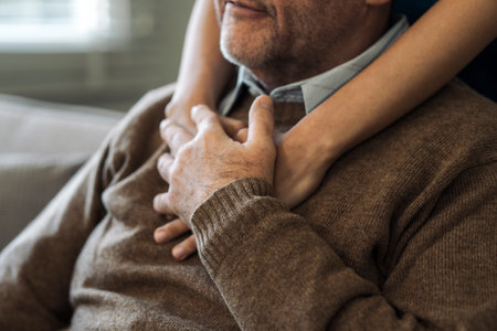 Caregiver encourages and hugs elderly man in nursing home care and confide in caregiverの写真素材