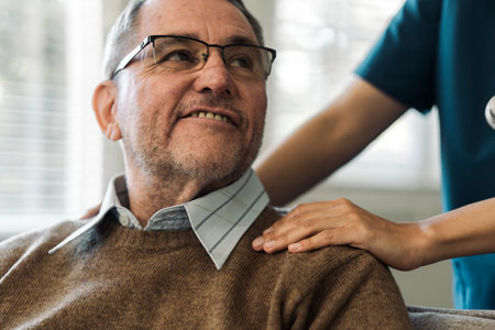 Caregiver encourages and comforts elderly man in nursing home care and confide in caregiverの写真素材