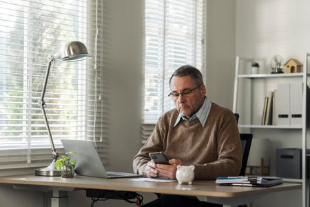 Retired old man is calculating stress about annual tax, debt, arrears in the house. Tax concept.の写真素材