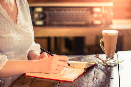Working woman at vintage style coffee shop. Start fresh new working day with tasty coffee,pencil and noteの写真素材
