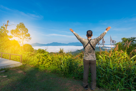 Man raising hands open arms at sunrise.Explore to highland mountain,man facing to the sun with sunlight early morning.の写真素材