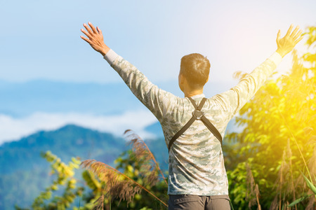 Man raising hands open arms at sunrise.Explore to highland mountain,man facing to the sun with sunlight early morning.の写真素材