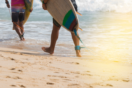 Young surfer with leg rope carrying surfboard walking to the sea.
Sunny day and big wave,paradise of surfer during vacation at tropical beach.の写真素材