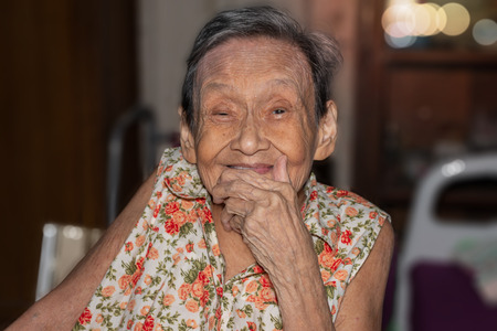 Portrait of a happy elderly woman in colorful dress smiling while sitting in home.
90 up of healthy woman,front view.の写真素材