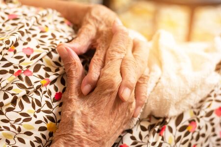 Close up hands of healthy woman aged over 90 joining together with natural light in background,side view.Hands of mom.の写真素材