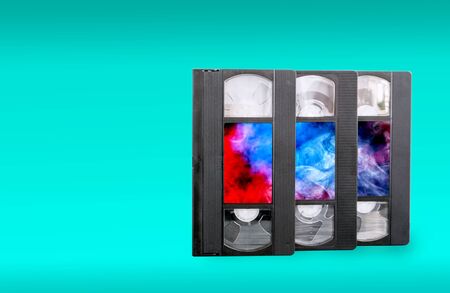 VHS video cassettes on a blue background and colorful stickersの写真素材