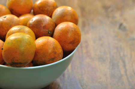Close up of Tangerine, Mandarin, Oranges in a Bowl on wood tableの写真素材