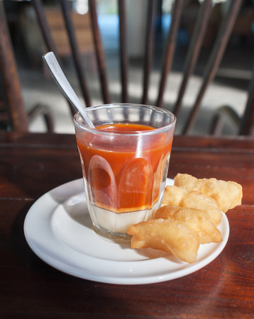 Hot milk tea with dough stick, Thai style breakfast or tea timeの写真素材