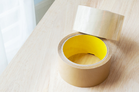 two roll of brown sticky tape on wood panel backgroundの写真素材