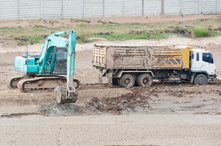 Blue Backhoe and truck work in the reservoir.