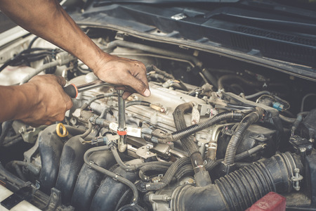 Hands of mechanic working in auto repair shop with processÂ  vintage styleの写真素材