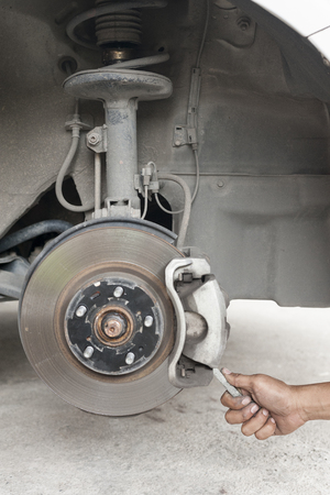 Hands of mechanic changing car braker pad in auto repair service.の写真素材