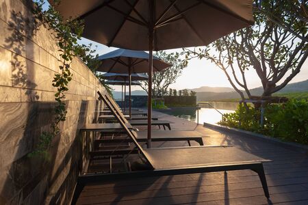 sunbed with pool at sunset