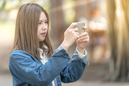 young woman using mobile phone for taking photo. の写真素材