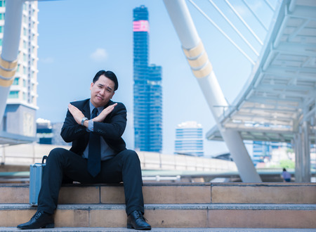 business man say no with crossed arms hands refusing and cancel concept with city blackgroundの写真素材