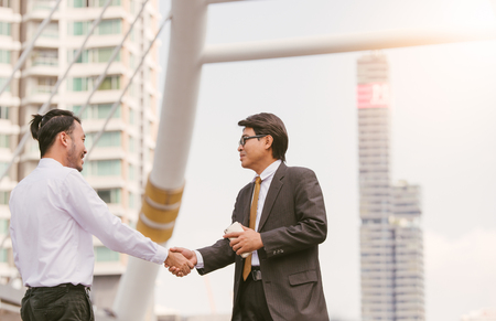 Business handshake. Handshake of two business men closing a deal city blackgroundの写真素材