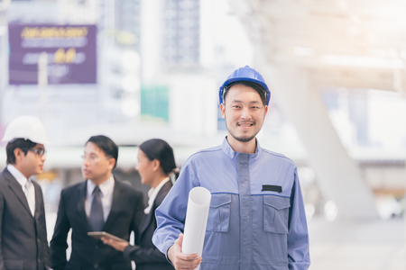 Portrait of civil engineer planing Construction, Maintenance and architect in helmet with city background with business people group blur Backgroundの写真素材