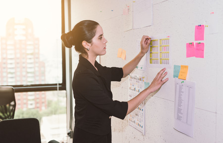 business woman discussing and planning concept. Front of wall marker and stickers. Startup office.の写真素材
