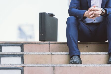 Young business man with newspaper sitting on the stairs.の写真素材